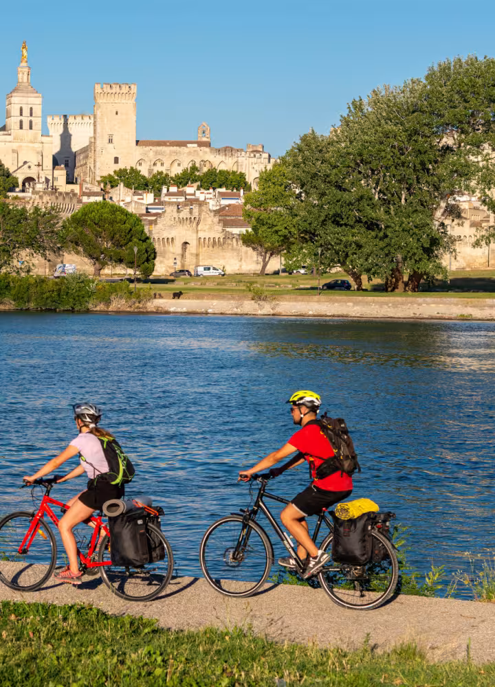Cyclists along the Rhône river in front of Arles