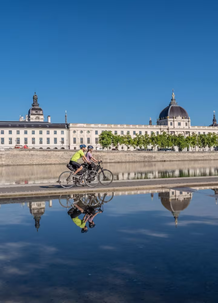 Cyclists passing in front of the Grand Hôtel-Dieu in Lyon