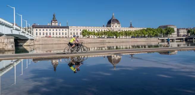 Cyclists passing in front of the Grand Hôtel-Dieu in Lyon