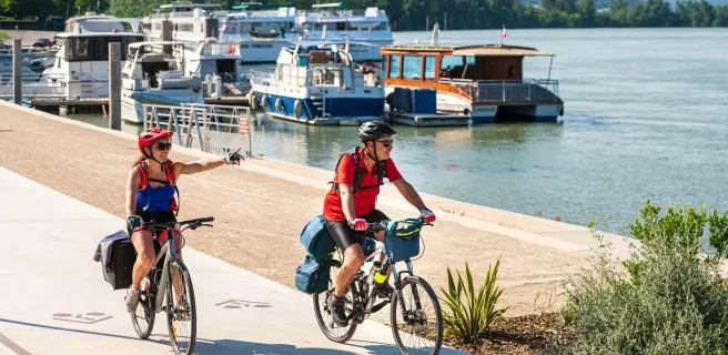 Couple cycling along the quays of Tournon sur Rhône (Ardèche)