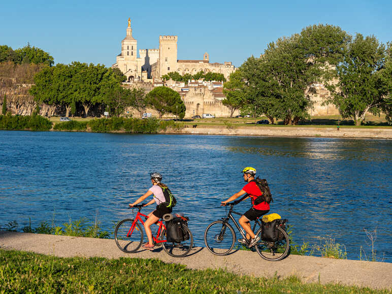 Cyclists along the Rhône river in front of  Arles